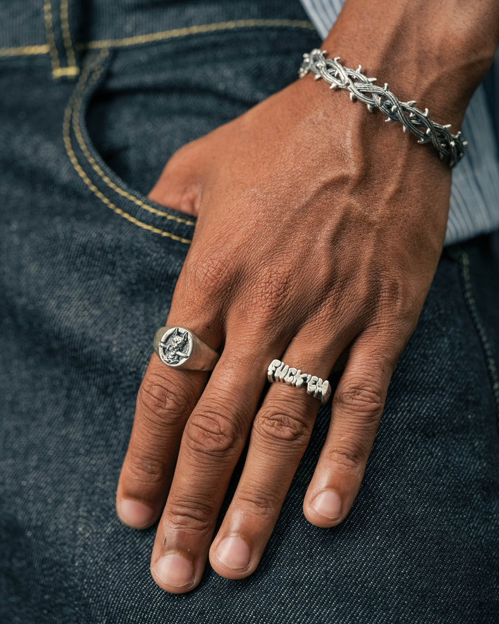 dog and dagger signet ring in silver and fuck ‘em ring in silver and thorn cuff in silver model photograph