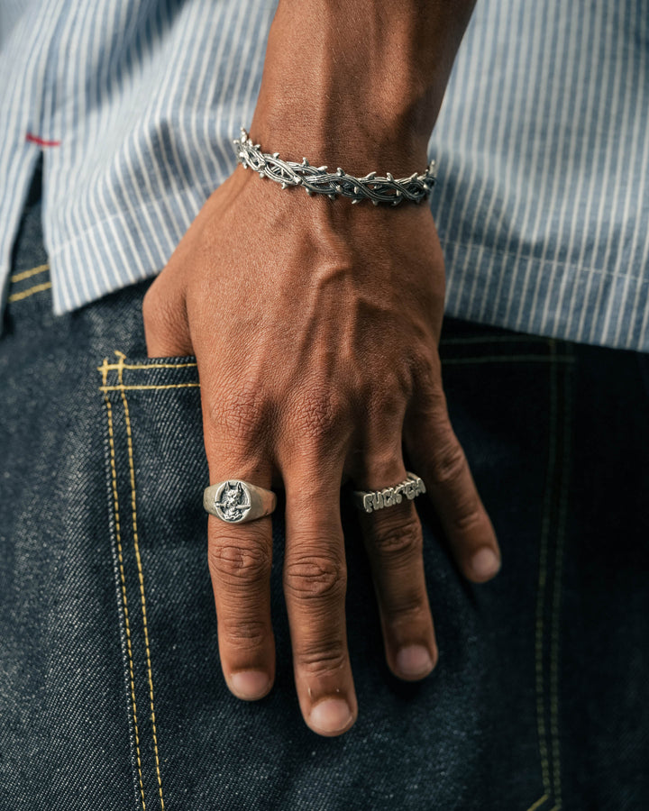 dog and dagger signet ring in silver and fuck ‘em ring in silver and thorn cuff in silver model photograph