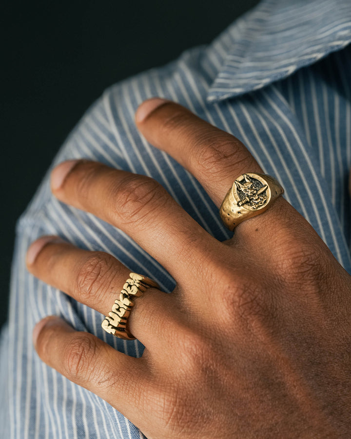 dog and dagger signet ring in gold and fuck ‘em ring in gold model photograph